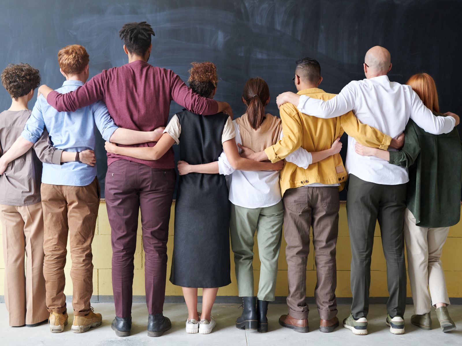 Eine Gruppe von Menschen steht Arm in Arm nebeneinander